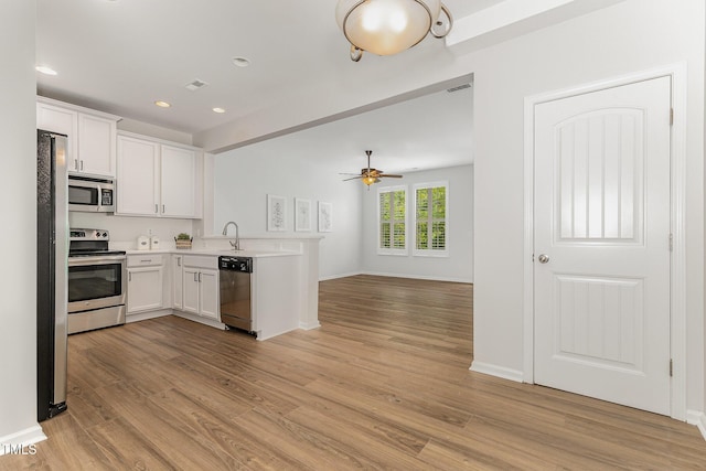 14309 Foxcroft Rd, Raleigh, NC 27614 - kitchen with stainless steel appliances, light wood-style floors, light countertops, white cabinets, and recessed lighting