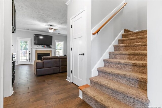 4112 Newgate St, Fayetteville, NC 28306 - stairs with a ceiling fan, a fireplace, crown molding, and wood finished floors