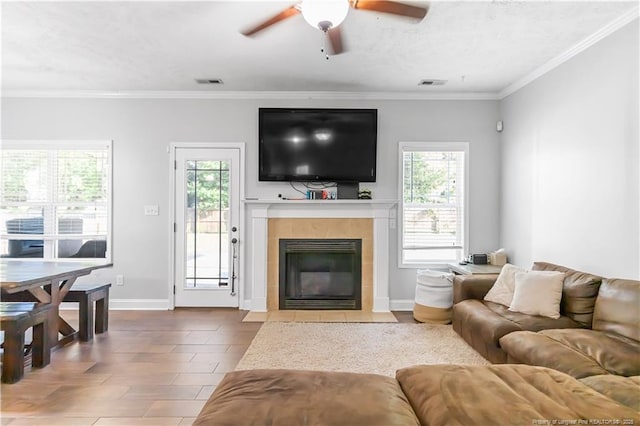 4112 Newgate St, Fayetteville, NC 28306 - living room featuring plenty of natural light, a ceiling fan, a tiled fireplace, and crown molding