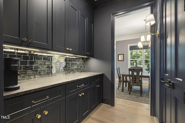 201 S Ennis St, Fuquay Varina, NC 27526 - kitchen featuring ornamental molding, light wood-style flooring, tasteful backsplash, and dark cabinets
