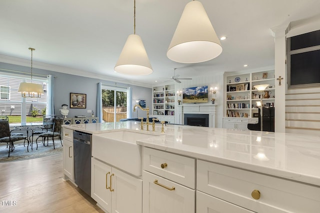 201 S Ennis St, Fuquay Varina, NC 27526 - kitchen with stainless steel dishwasher, ornamental molding, a fireplace, a ceiling fan, and light stone counters