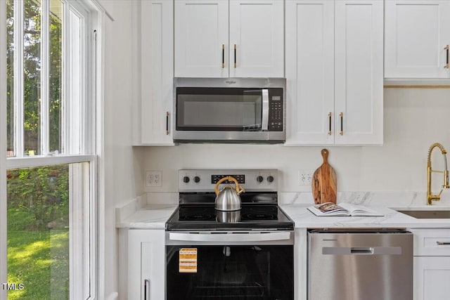 813 N Main St, Burlington, NC 27217 - kitchen with stainless steel appliances, white cabinets, healthy amount of natural light, and light stone countertops