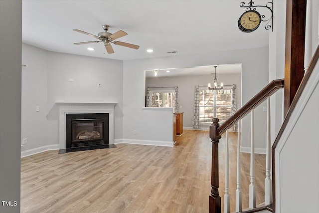 3021 Winding Waters Way, Raleigh, NC 27614 - unfurnished living room featuring light wood-style floors, recessed lighting, a chandelier, a ceiling fan, and a fireplace with flush hearth