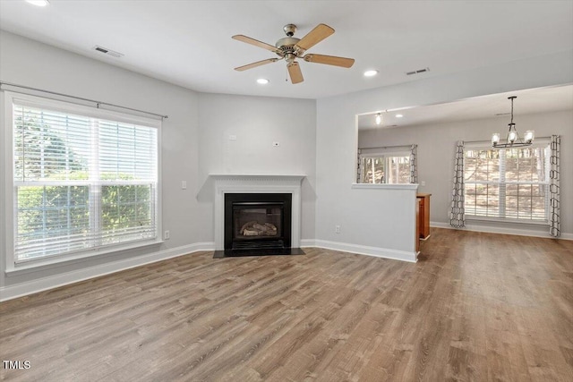 3021 Winding Waters Way, Raleigh, NC 27614 - unfurnished living room featuring a chandelier, wood finished floors, a ceiling fan, a fireplace with flush hearth, and recessed lighting