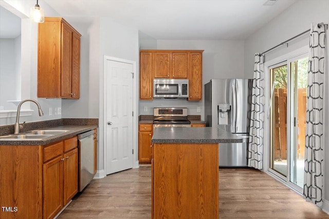 3021 Winding Waters Way, Raleigh, NC 27614 - kitchen featuring appliances with stainless steel finishes, dark countertops, a center island, and wood finished floors