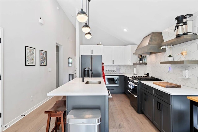 1103 S Bloodworth St, Raleigh, NC 27601 - kitchen with stainless steel appliances, range hood, open shelves, backsplash, and light countertops