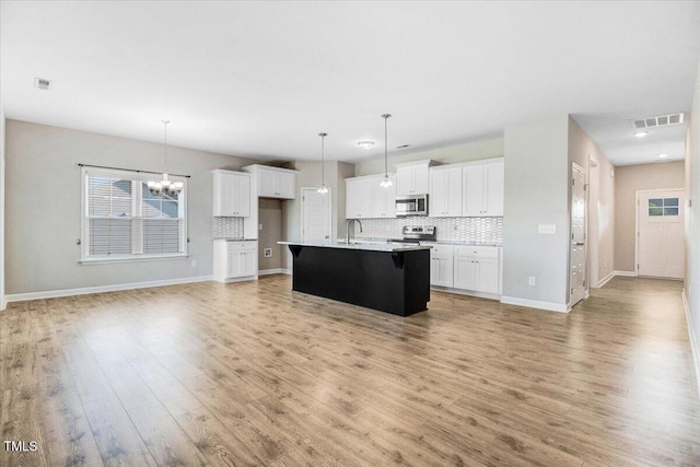 106 Fynloch Chase Dr, Fremont, NC 27830 - kitchen with stainless steel appliances, decorative backsplash, a chandelier, light wood-style floors, and white cabinets