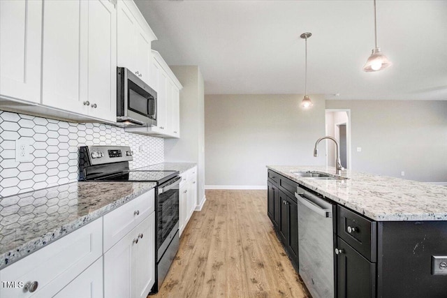 106 Fynloch Chase Dr, Fremont, NC 27830 - kitchen featuring appliances with stainless steel finishes, dark cabinetry, white cabinets, decorative backsplash, and light wood-type flooring