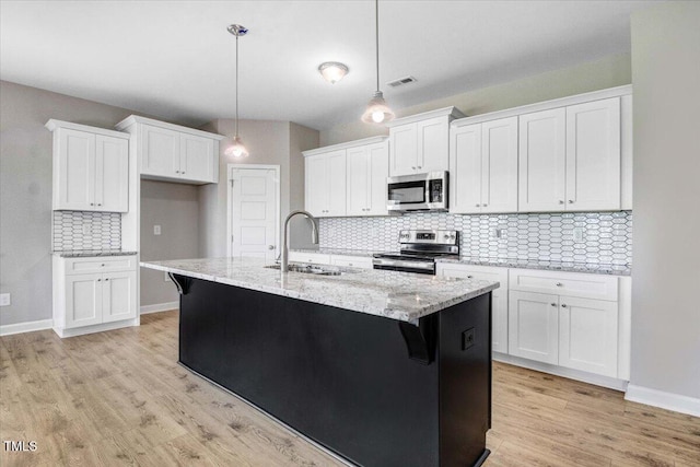 106 Fynloch Chase Dr, Fremont, NC 27830 - kitchen with stainless steel appliances, decorative backsplash, light wood-type flooring, and white cabinetry
