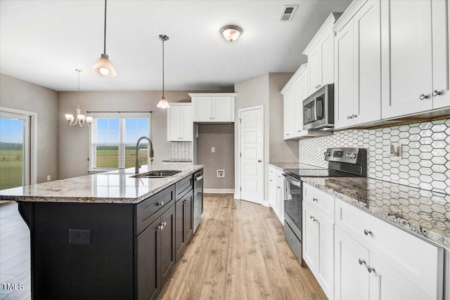 106 Fynloch Chase Dr, Fremont, NC 27830 - kitchen featuring appliances with stainless steel finishes, backsplash, white cabinetry, light wood-type flooring, and light stone counters