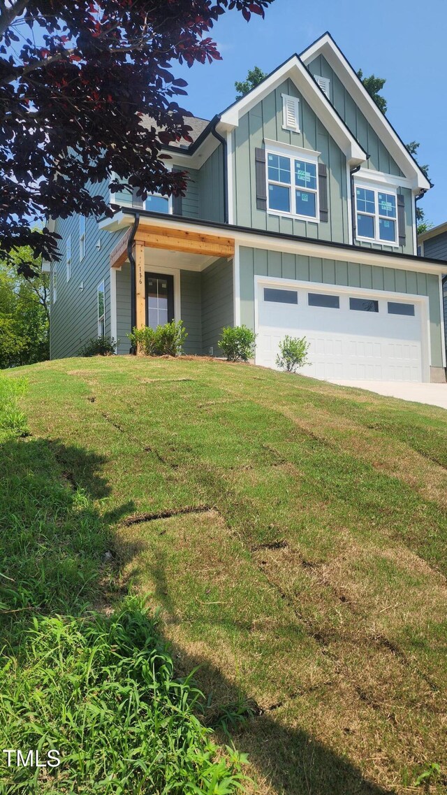 116 Chestnut St, Durham, NC 27707 - view of front facade with an attached garage, board and batten siding, a front lawn, and concrete driveway