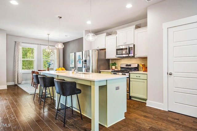 644 Granite Mill Blvd, Chapel Hill, NC 27516 - kitchen featuring stainless steel appliances, a kitchen island with sink, dark wood-style flooring, a kitchen breakfast bar, and light countertops