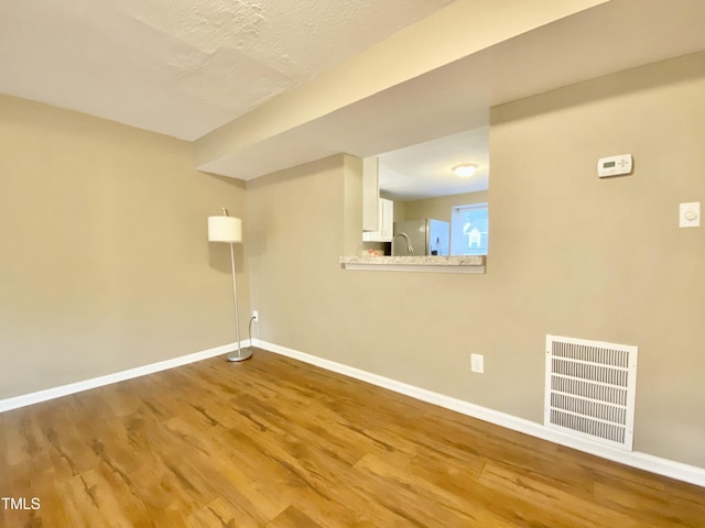 4324 Halliwell Dr, Raleigh, NC 27606 - below grade area featuring freestanding refrigerator and wood finished floors