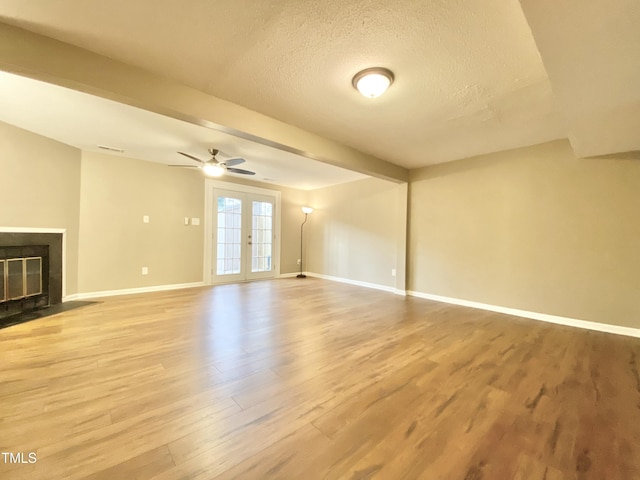 4324 Halliwell Dr, Raleigh, NC 27606 - unfurnished living room featuring light wood finished floors, a textured ceiling, french doors, a fireplace with flush hearth, and a ceiling fan