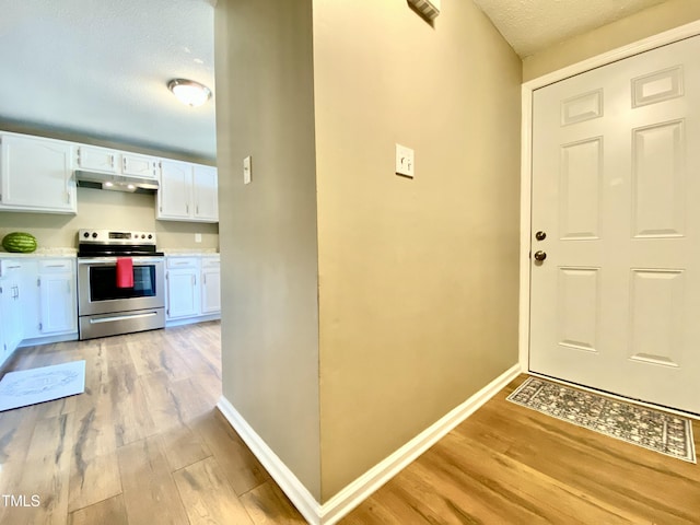 4324 Halliwell Dr, Raleigh, NC 27606 - kitchen featuring electric stove, under cabinet range hood, light wood-style floors, white cabinets, and light countertops