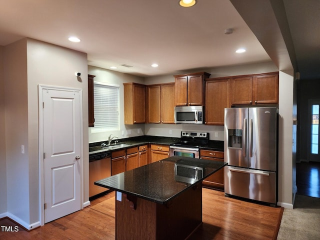 302 Glenview Ln, Durham, NC 27703 - kitchen with stainless steel appliances, recessed lighting, light wood-style flooring, a center island, and dark stone counters