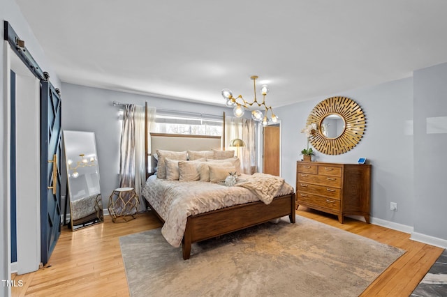 1603 N Alston Ave, Durham, NC 27701 - bedroom with light wood-style flooring, a barn door, and a chandelier