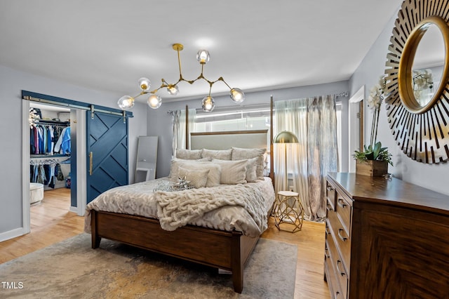 1603 N Alston Ave, Durham, NC 27701 - bedroom with a barn door, light wood-style floors, and a spacious closet