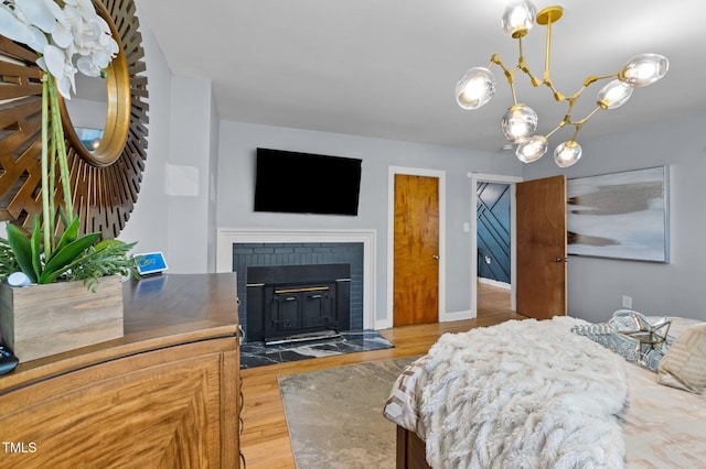 1603 N Alston Ave, Durham, NC 27701 - bedroom with a chandelier, wood finished floors, and a brick fireplace