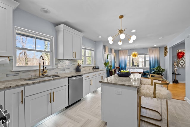 1603 N Alston Ave, Durham, NC 27701 - kitchen featuring stainless steel dishwasher, a chandelier, a kitchen breakfast bar, a kitchen island, and white cabinets