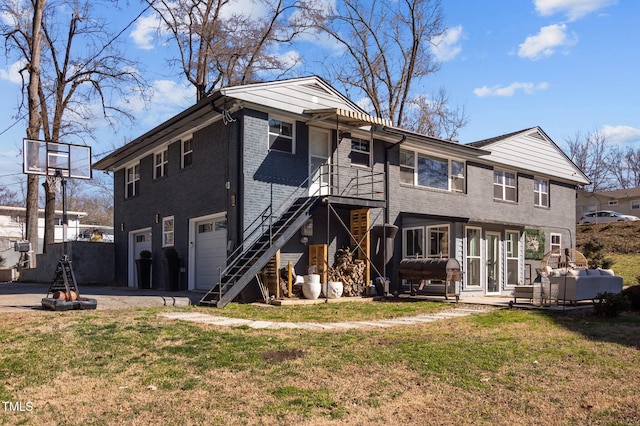 1603 N Alston Ave, Durham, NC 27701 - rear view of property featuring a garage, stairway, brick siding, driveway, and a lawn