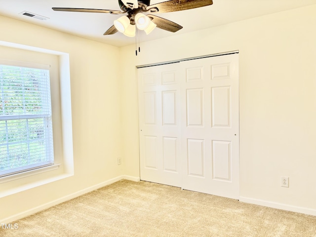 1121 Brookhill Way, Cary, NC 27519 - unfurnished bedroom with light colored carpet, multiple windows, a closet, and ceiling fan