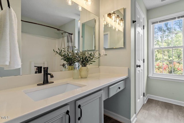 404 Ascott Way, Durham, NC 27713 - full bathroom featuring vanity, wood finished floors, plenty of natural light, and a shower with shower curtain
