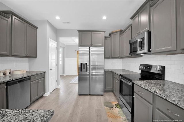 208 Walker Downs Cir, Fayetteville, NC 28305 - kitchen with stainless steel appliances, gray cabinetry, stone counters, light wood-style floors, and recessed lighting