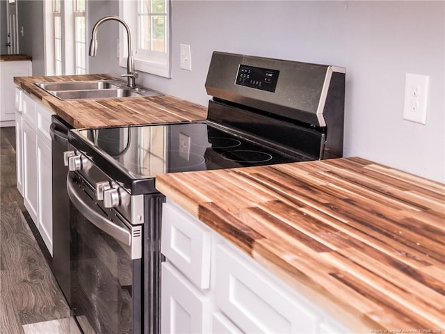 40 Ella Bell Rd, Clarkton, NC 28433 - kitchen with butcher block counters, stainless steel range with electric cooktop, white cabinets, and dark wood-type flooring