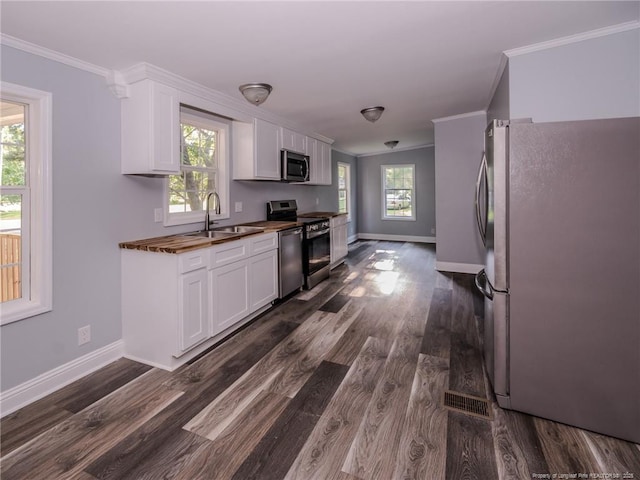 40 Ella Bell Rd, Clarkton, NC 28433 - kitchen with appliances with stainless steel finishes, crown molding, white cabinetry, and dark wood-type flooring