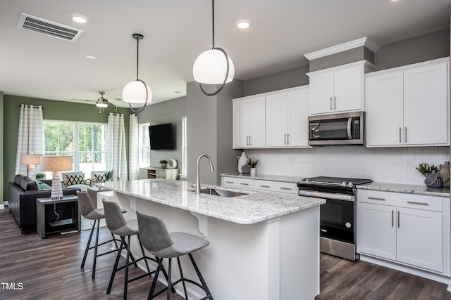 288 Fosterton Cottage Way, Raleigh, NC 27603 - kitchen featuring stainless steel appliances, dark wood-style flooring, backsplash, open floor plan, and recessed lighting