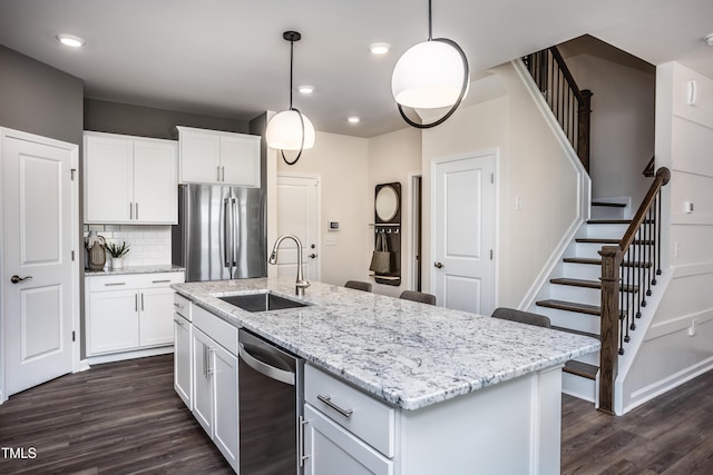 288 Fosterton Cottage Way, Raleigh, NC 27603 - kitchen with appliances with stainless steel finishes, dark wood-style flooring, tasteful backsplash, light stone countertops, and white cabinetry