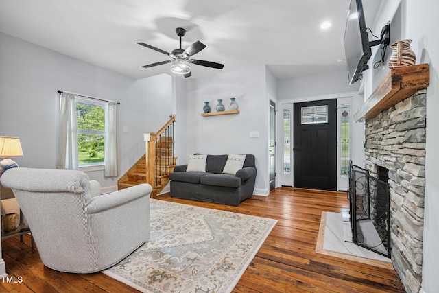 605 W Holt St, Mebane, NC 27302 - living area featuring stairs, hardwood / wood-style floors, a stone fireplace, and ceiling fan