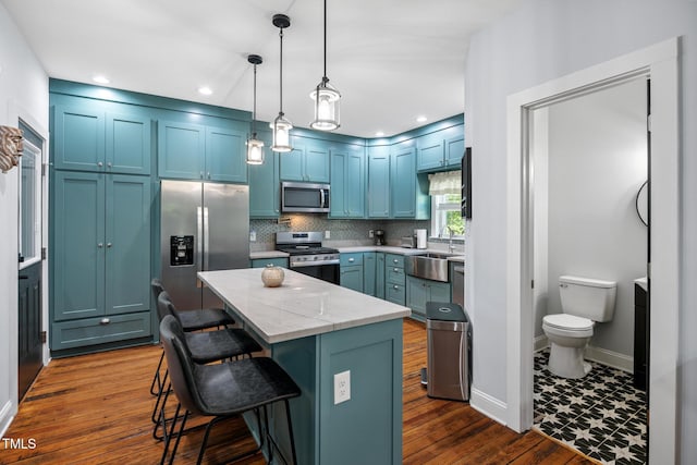 605 W Holt St, Mebane, NC 27302 - kitchen featuring stainless steel appliances, a center island, a breakfast bar, decorative backsplash, and light stone countertops