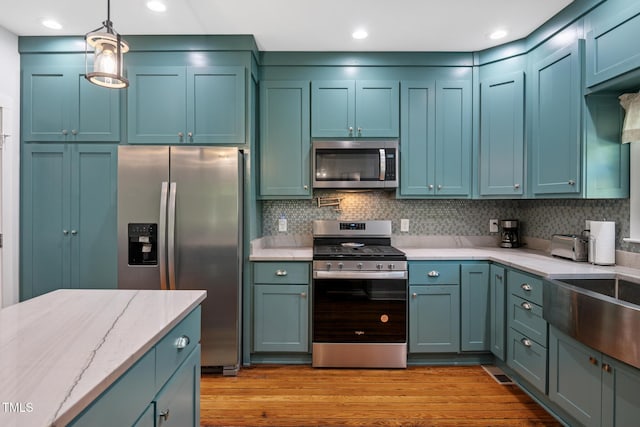 605 W Holt St, Mebane, NC 27302 - kitchen featuring stainless steel appliances, decorative light fixtures, light wood-style flooring, light stone countertops, and tasteful backsplash