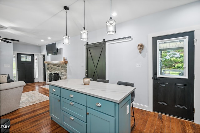 605 W Holt St, Mebane, NC 27302 - kitchen featuring a barn door, open floor plan, a breakfast bar, ceiling fan, and dark wood-style floors