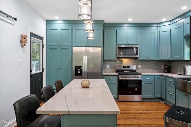 605 W Holt St, Mebane, NC 27302 - kitchen with appliances with stainless steel finishes, light wood-style flooring, backsplash, a kitchen bar, and a kitchen island