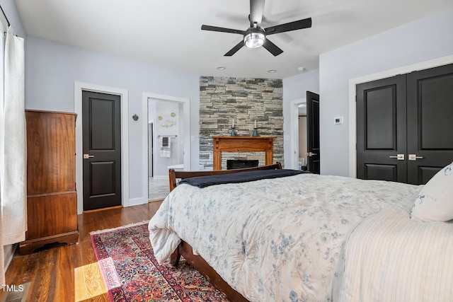 605 W Holt St, Mebane, NC 27302 - bedroom with wood finished floors, a closet, a stone fireplace, and a ceiling fan