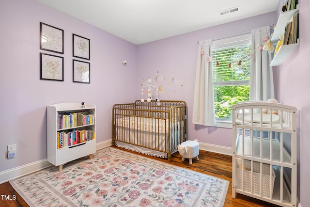 605 W Holt St, Mebane, NC 27302 - bedroom with wood finished floors and a crib