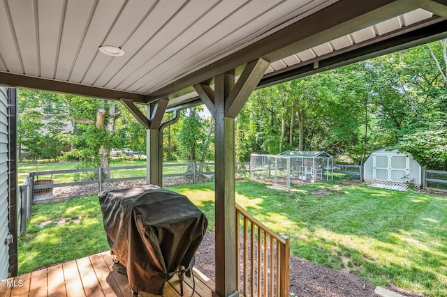 605 W Holt St, Mebane, NC 27302 - wooden terrace featuring a fenced backyard, area for grilling, a storage shed, an exterior structure, and view of wooded area