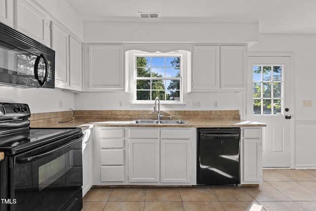 7 Hannah Ct, Durham, NC 27713 - kitchen featuring black appliances, light tile patterned floors, and white cabinetry