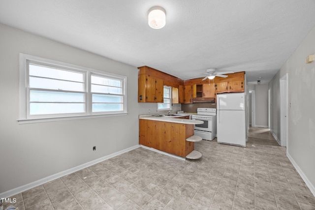 150 Alston Pruitt Rd, Louisburg, NC 27549 - kitchen featuring white appliances, a peninsula, brown cabinetry, light countertops, and a ceiling fan