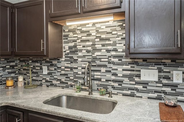 5411 Archer Rd, Hope Mills, NC 28348 - kitchen with dark brown cabinets, decorative backsplash, and light stone countertops