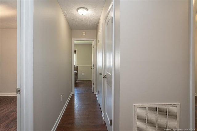 5411 Archer Rd, Hope Mills, NC 28348 - corridor with a textured ceiling and dark wood-type flooring