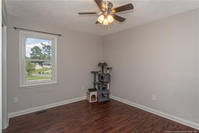 5411 Archer Rd, Hope Mills, NC 28348 - unfurnished room with a textured ceiling, wood finished floors, ceiling fan, and a wood stove