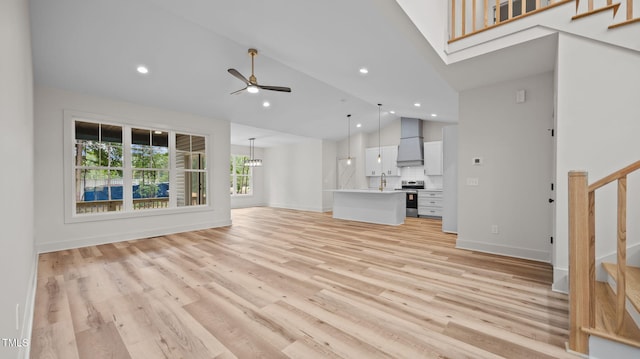 5027 Preacher Holmes Rd, Graham, NC 27253 - unfurnished living room featuring stairs, light wood-type flooring, a ceiling fan, recessed lighting, and high vaulted ceiling
