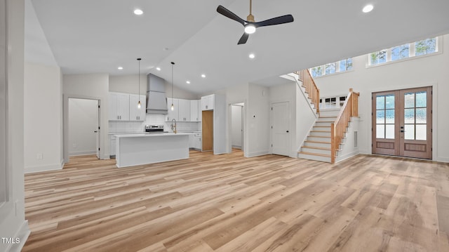 5027 Preacher Holmes Rd, Graham, NC 27253 - unfurnished living room with high vaulted ceiling, french doors, stairs, recessed lighting, and light wood-style floors