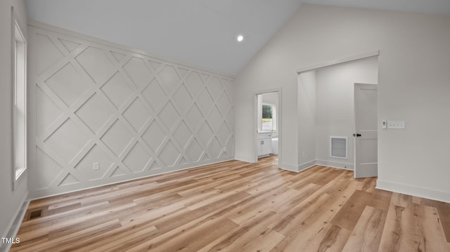 5027 Preacher Holmes Rd, Graham, NC 27253 - spare room featuring light wood-style floors, recessed lighting, high vaulted ceiling, and a decorative wall