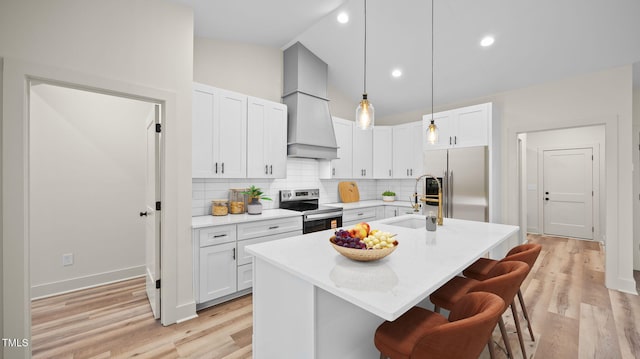 5027 Preacher Holmes Rd, Graham, NC 27253 - kitchen with appliances with stainless steel finishes, a kitchen breakfast bar, premium range hood, decorative backsplash, and light wood finished floors