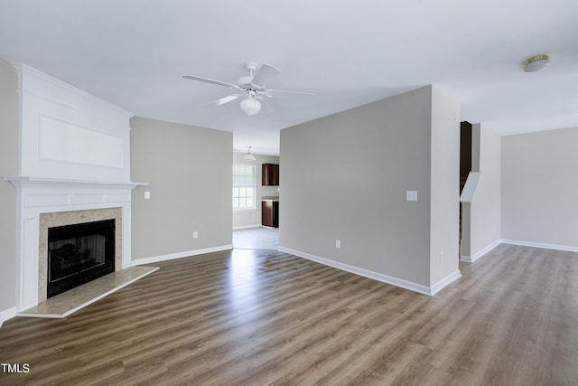 103 Bermuda Green Dr, Durham, NC 27703 - unfurnished living room featuring a fireplace with raised hearth, ceiling fan, and wood finished floors